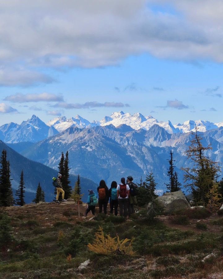 Hikers looking out at snow-capped North Cascades peaks
