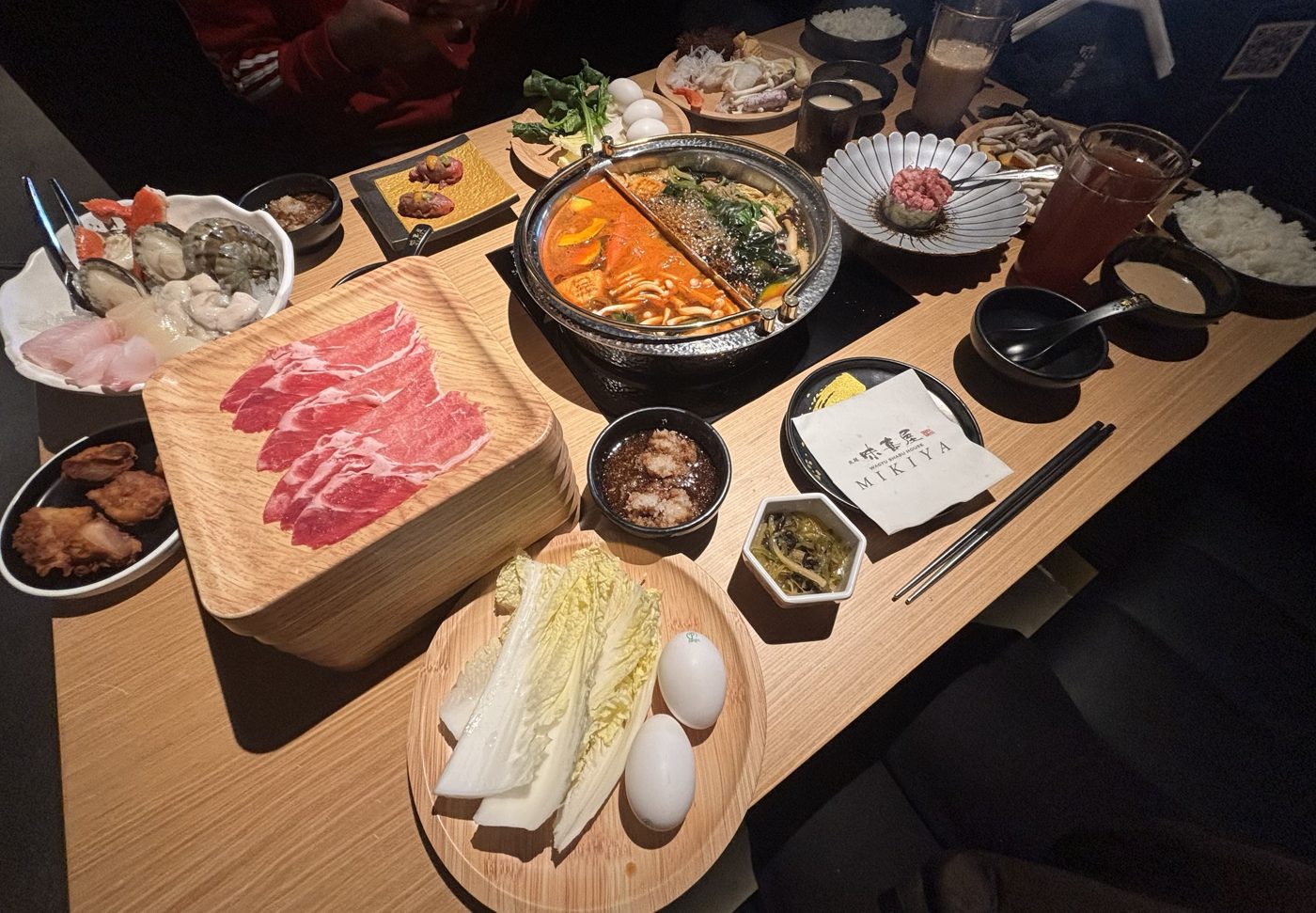 Wagyu shabu-shabu spread at Mikiya with a split hot pot, sliced wagyu, seafood and vegetables